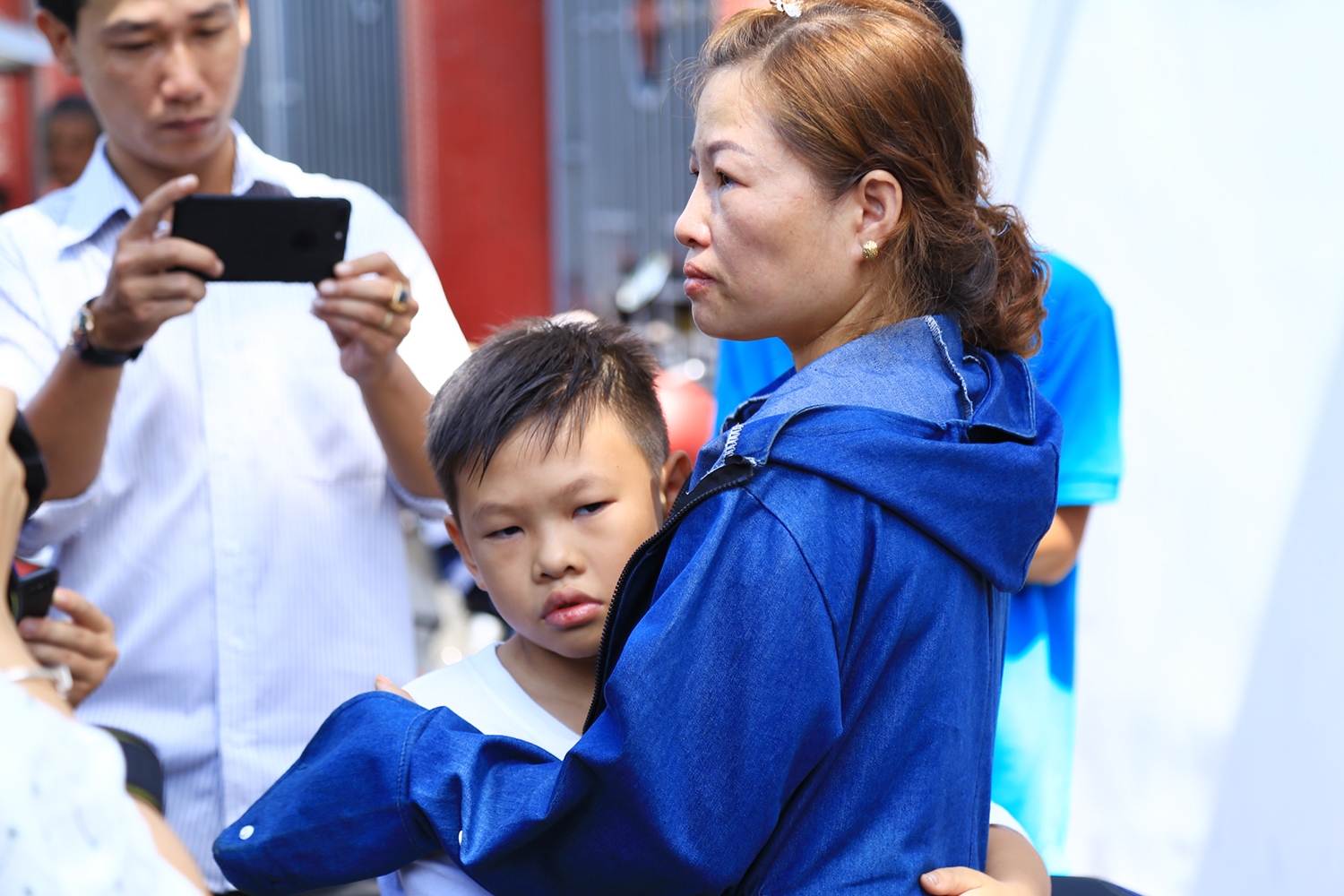 Chị Dung ôm con trai và động viên trong lúc chờ nhận thi thể chồng cũ. (Ảnh: Xuyến Chi)